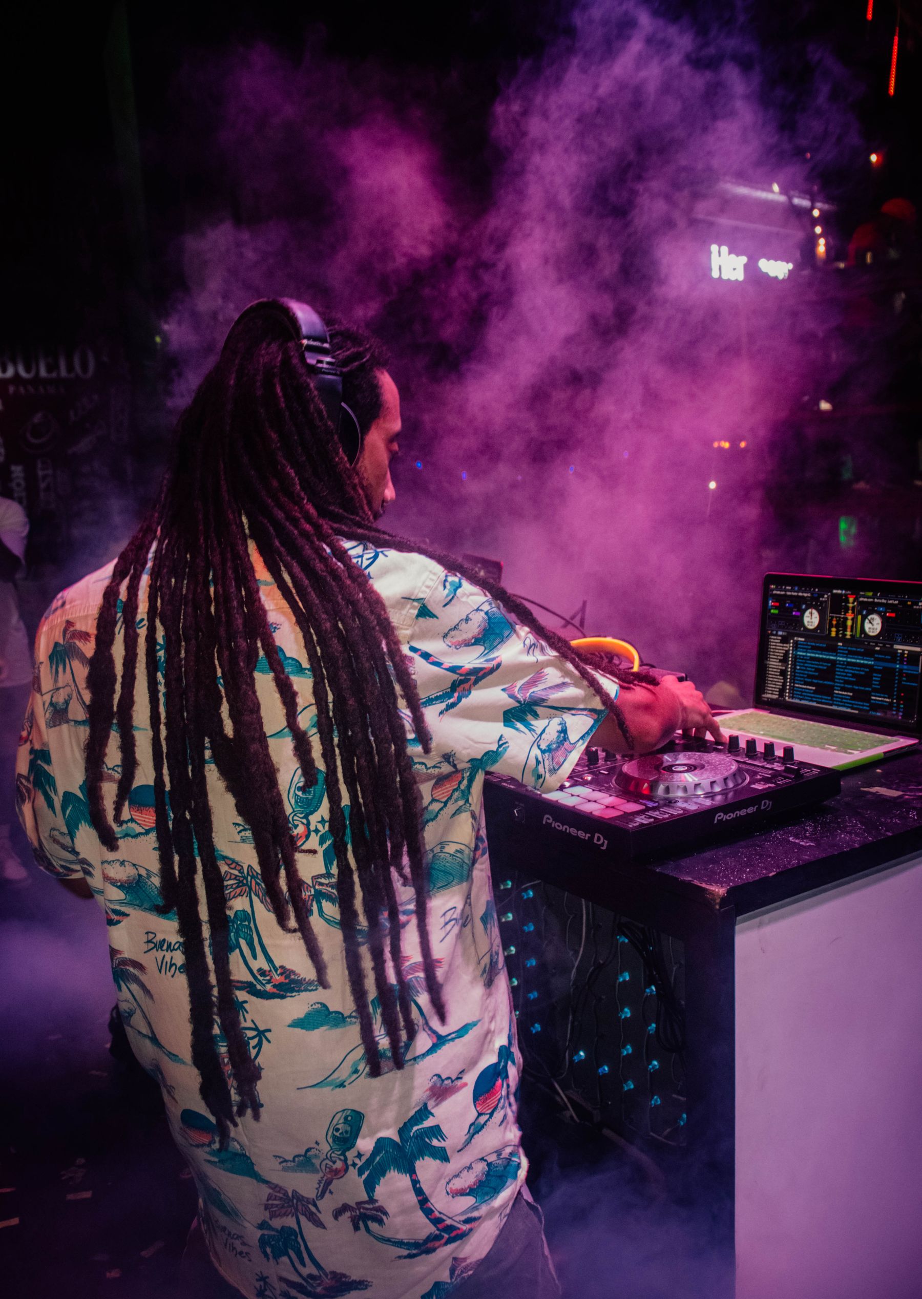 DJ working at a nightclub console in dramatic light