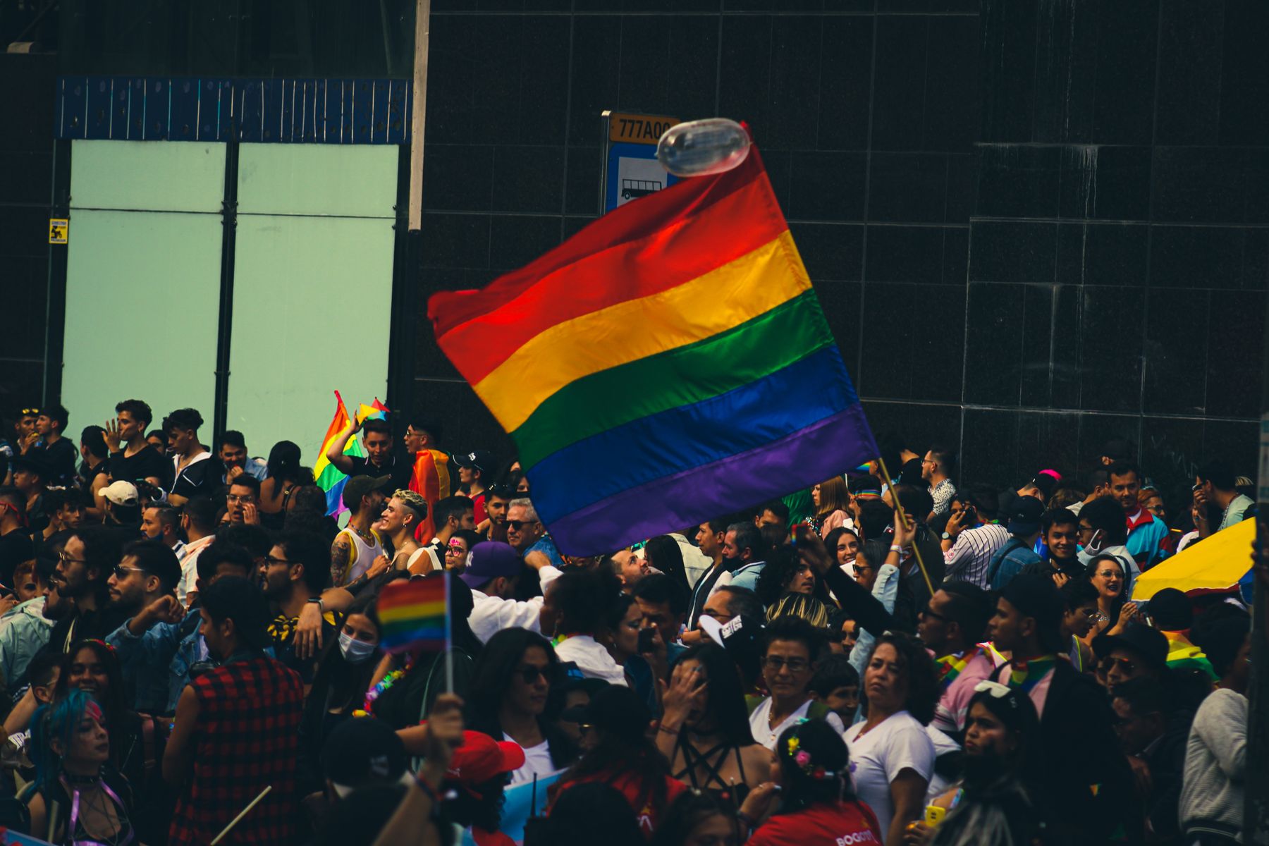 Crowd celebrating Pride with colourful rainbow flags