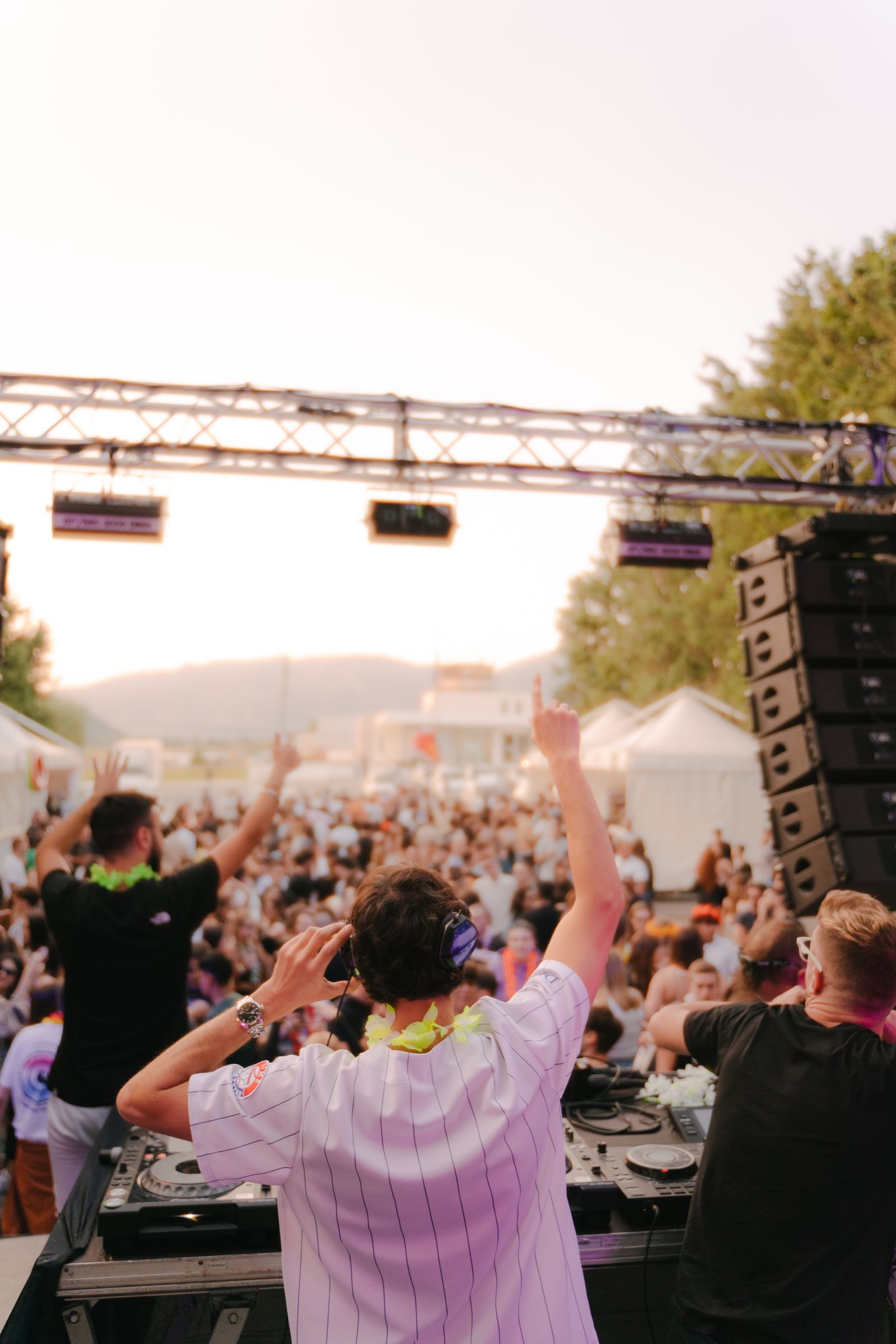 DJs performing on an outdoor festival stage in front of a crowd
