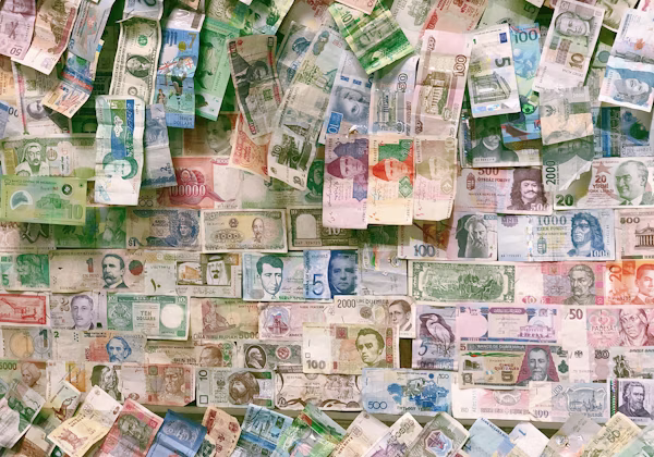 A collage of international banknotes pinned to a wall