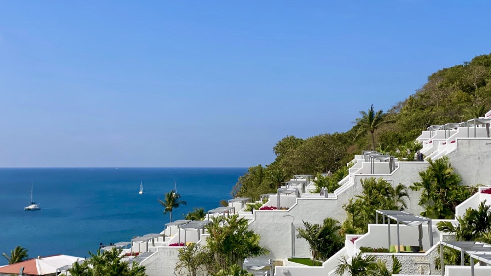 White stepped resort residences on a tropical Phuket hillside above the Andaman Sea